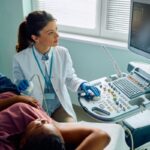 female looking at sonogram while doing ultrasound